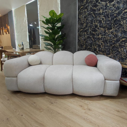 Vista frontal del Sofá Nube moderno en color blanco, diseño abstracto y patas redondas en madera.