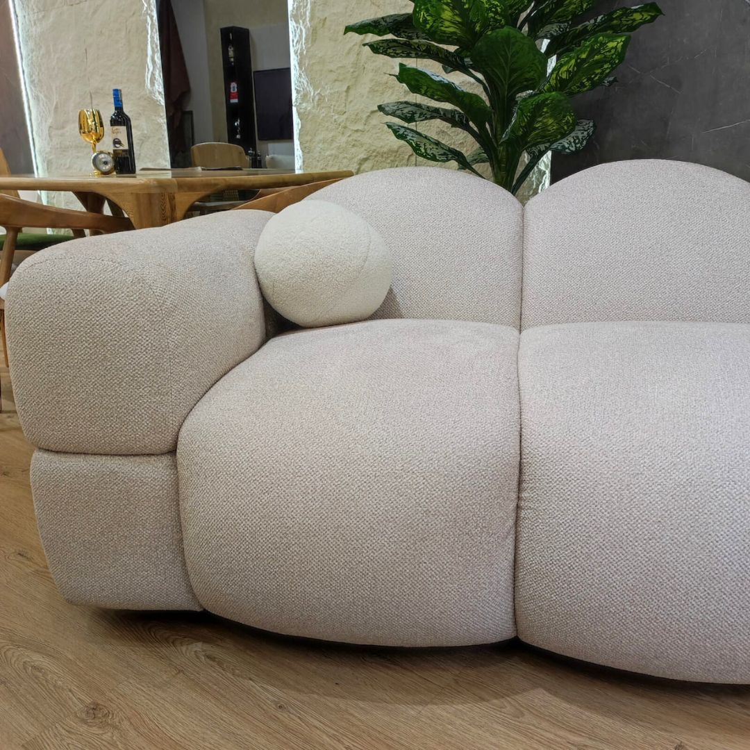 Acercamiento lado izquierdo sofá nube con cojin bola, en forma esférica y detalle de las costuras y pliegues.